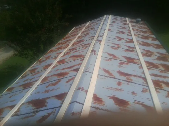 Rusted metal roof panels with new wood purlins before replacement — Storm Damage Roof Repair in Pinehurst by Roofing Brothers