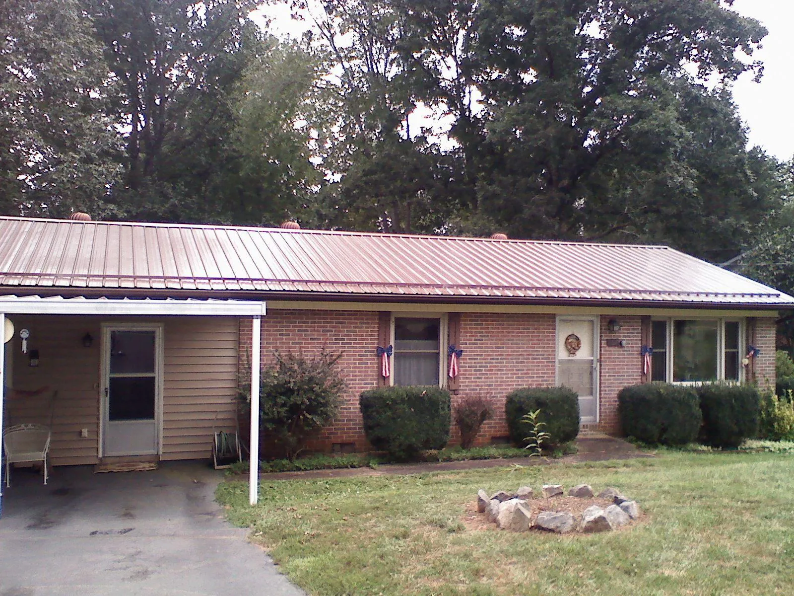Bronze metal roof and carport on a brick ranch home — Roof Repair work by our crew in Pinehurst