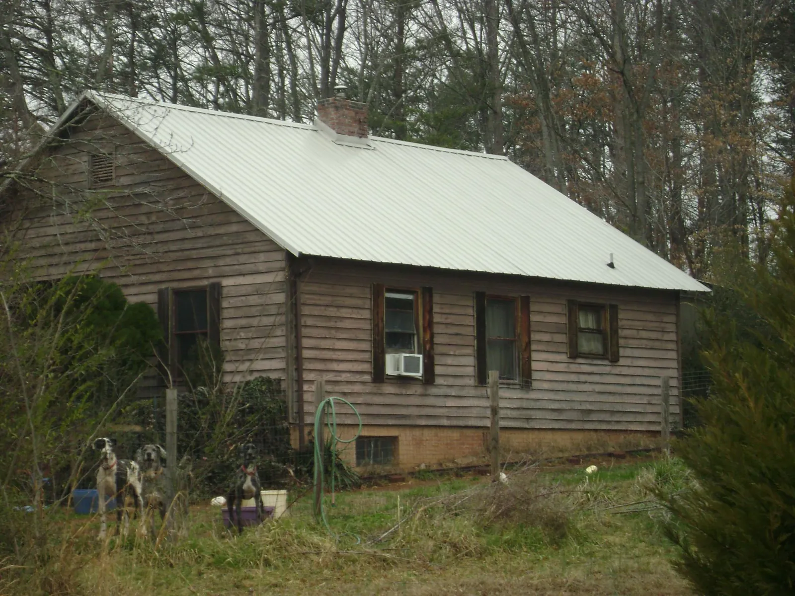 White metal roof on an old wood sided farmhouse, from a Asphalt Shingle Roof Repair job in Pinehurst